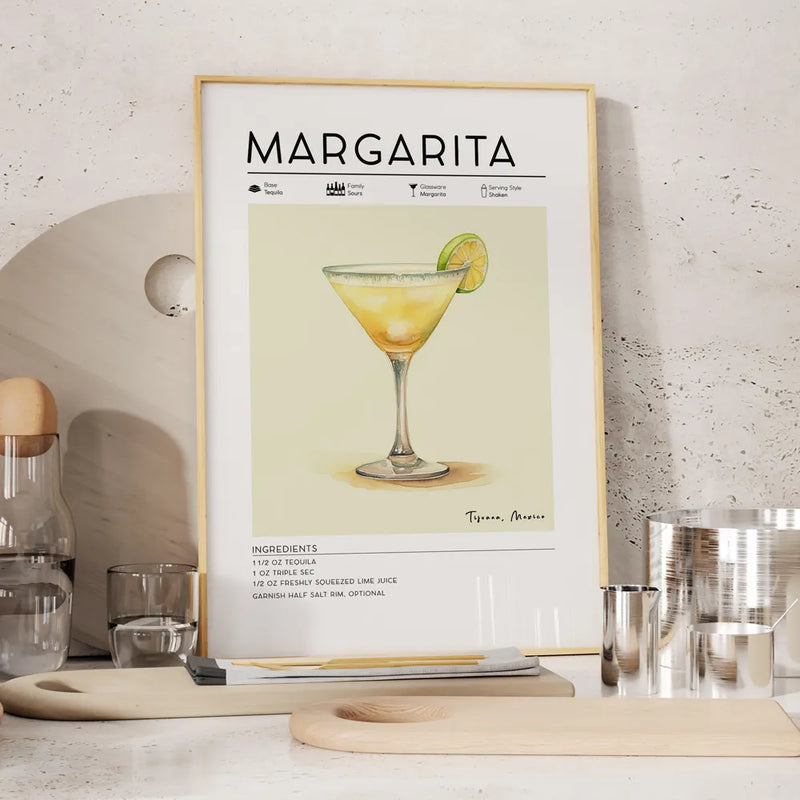 Framed poster of a margarita recipe on a kitchen counter with kitchenware.