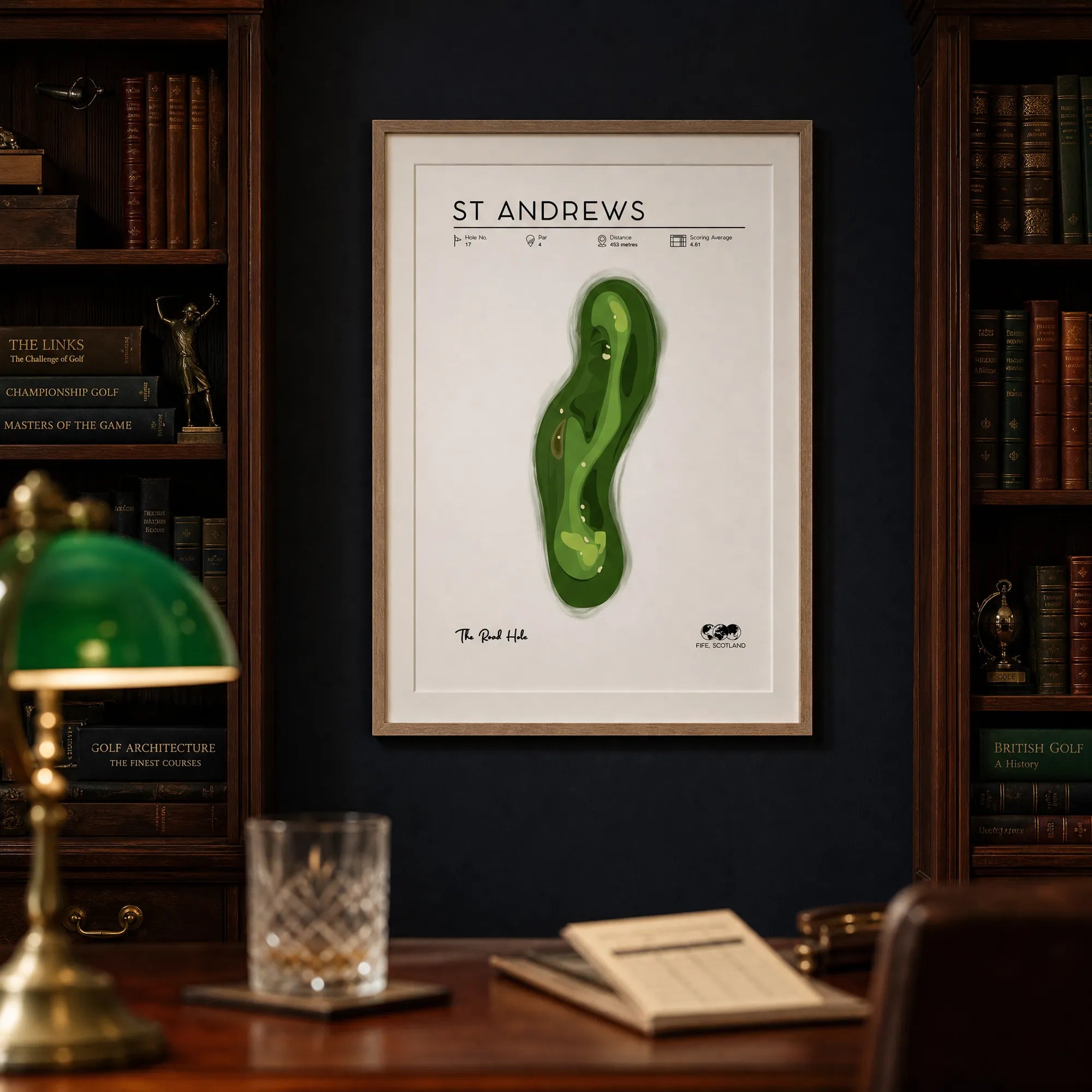 St Andrews golf print on a navy wall in a traditional home study, dark oak desk, warm evening light, light oak frame