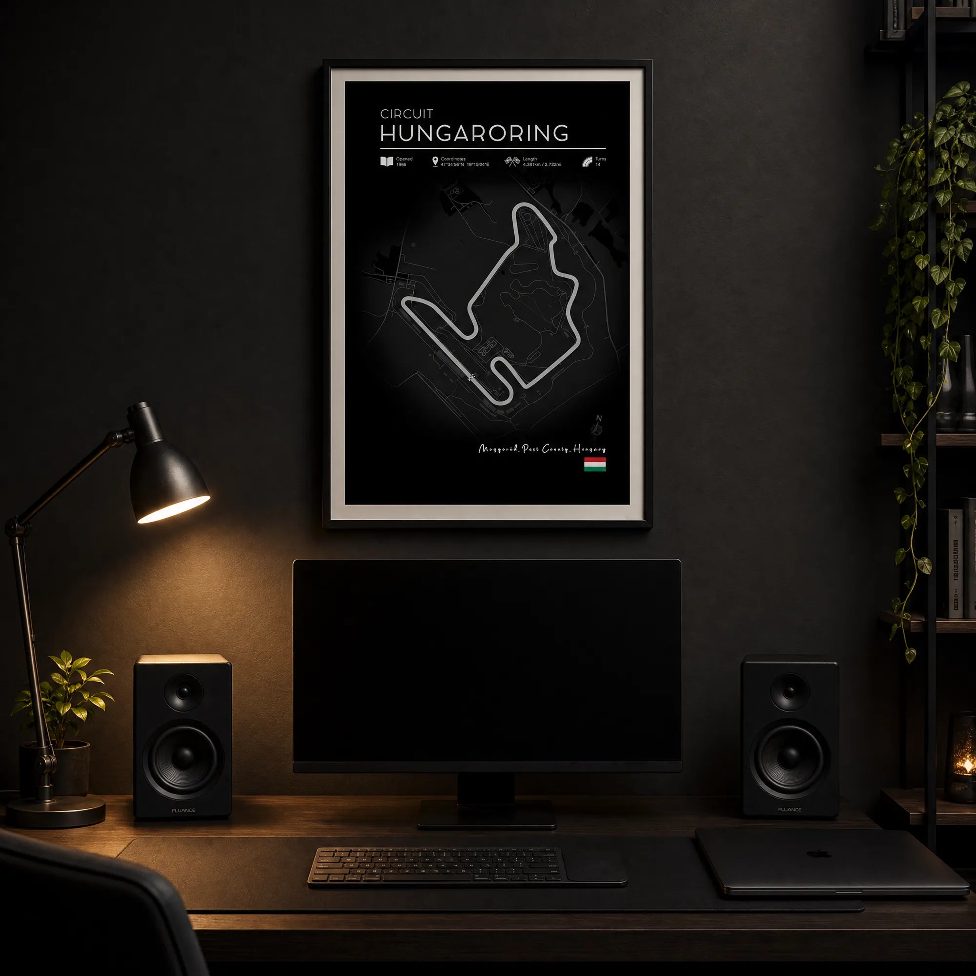 Hungaroring F1 track wall art black edition dark frame above minimal desk with monitor and bookshelf speakers
