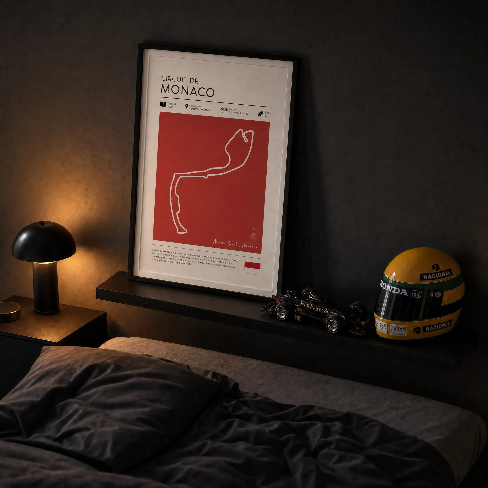 Monaco F1 track poster in black frame on dark bedroom wall with Ayrton Senna helmet and Formula 1 model car