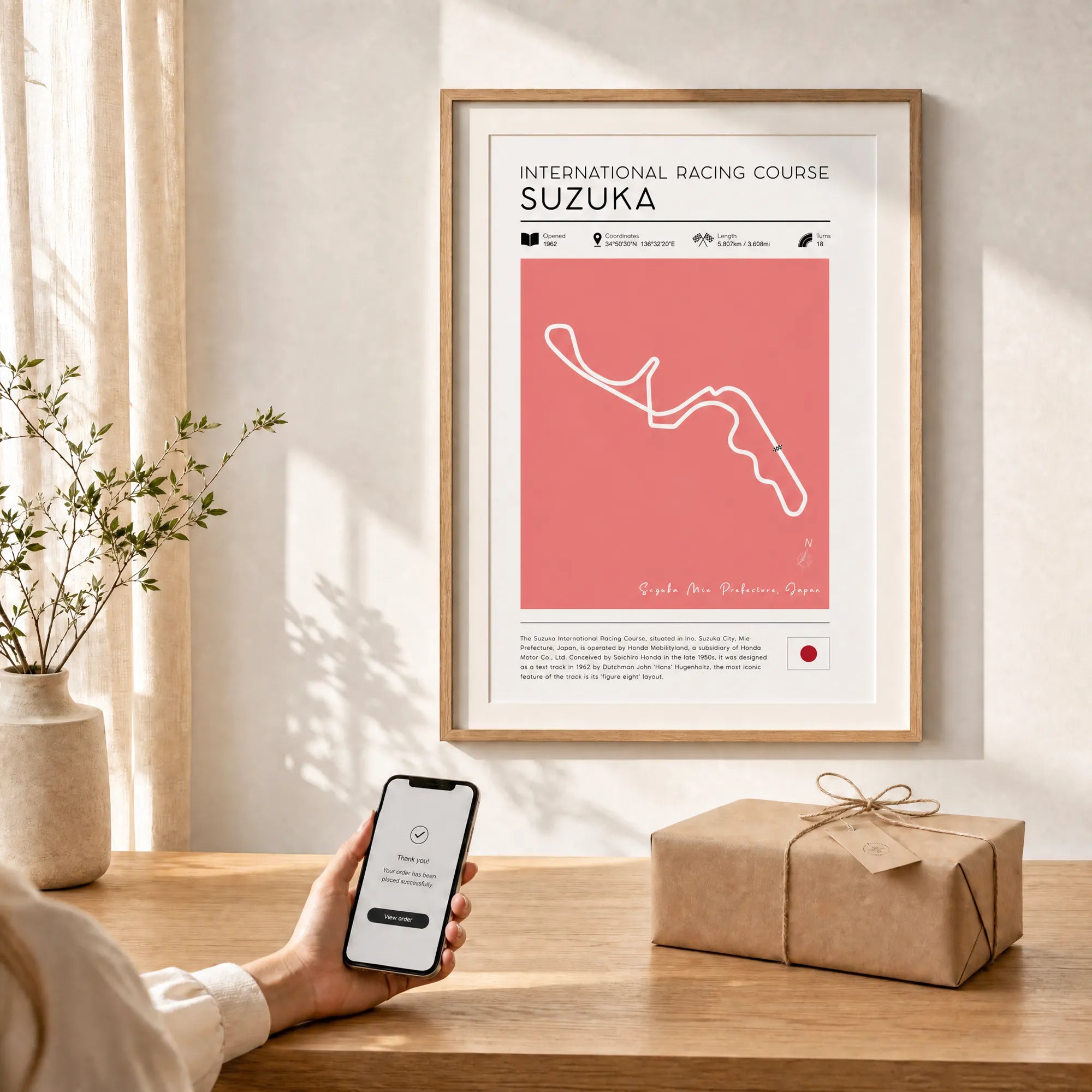 Suzuka Japanese Grand Prix poster framed on wall with wrapped gift below