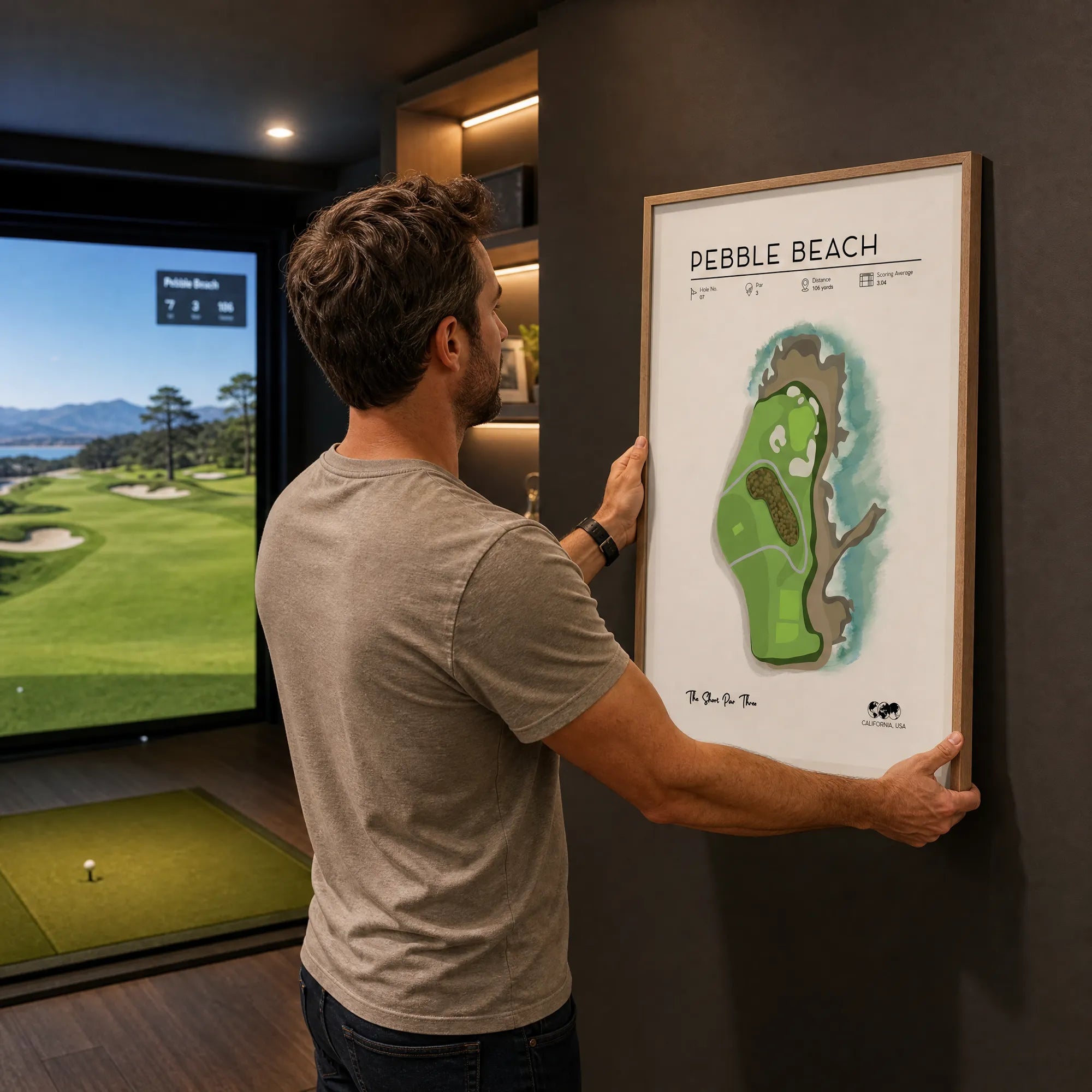 Golf gifts for men, man hanging framed golf course map print in home simulator room, charcoal wall, oak frame