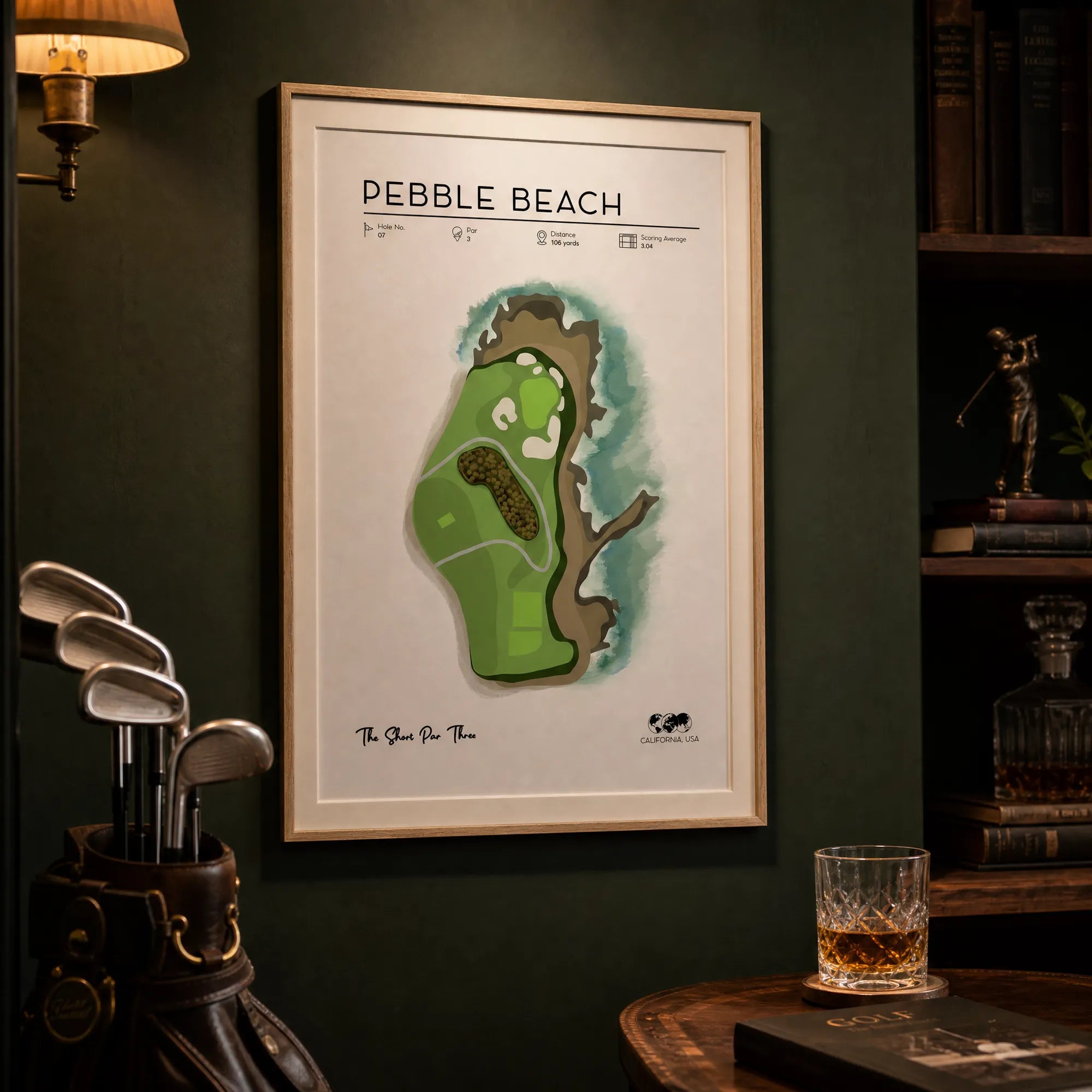 Pebble Beach golf print in a light oak frame above a dark oak home office desk, teal-grey wall, natural morning light